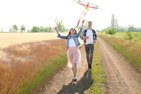快乐的年轻夫妇在田野里放飞风筝