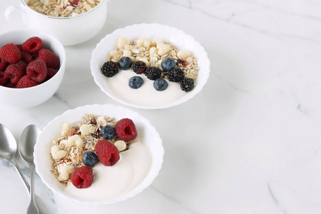 美味和健康的素食食品麦片, 酸奶, 新鲜浆果覆盆子, 蓝莓的大理石背景。顶部视图。复制空间