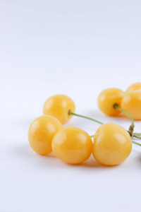 黄色樱桃在白色背景, 新鲜樱桃与绿叶, 黄色浆果在简约风格, 素食食物, 空白为设计师, 隔绝