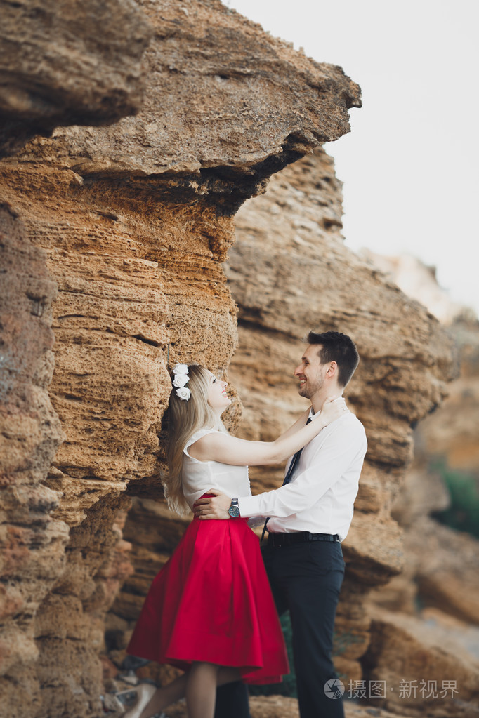 浪漫恩爱的夫妻,用石头和岩石海滩上散步
