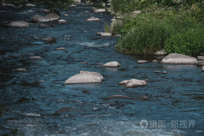 快速的小河与石头沿风景如画的海岸的河的迅速流动