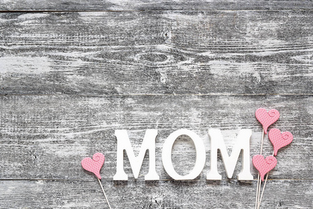 母亲一天消息与在灰色的木制装饰粉红色的心
