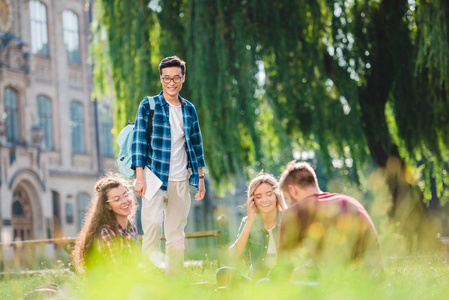 以大学为背景的多种族学生在公园里休息