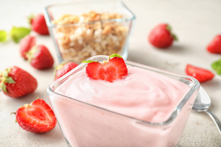 碗与可口草莓酸奶在轻的桌