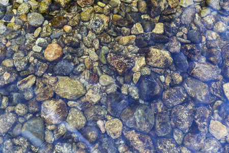 在清澈的水下, 在河底的圆石照片