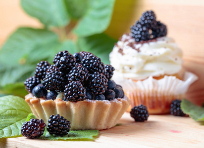 美味的黑莓蛋糕与浆果和奶油在一张木桌上