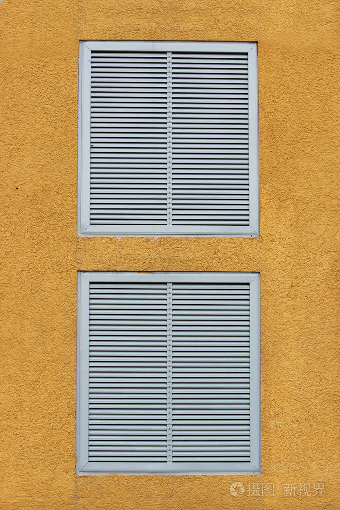 一个大型工业购物中心的两扇窗户以通风栅的形式封闭, 外部百叶窗.