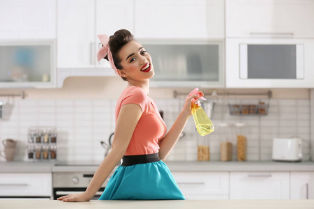 有趣的年轻主妇与洗涤剂在厨房里