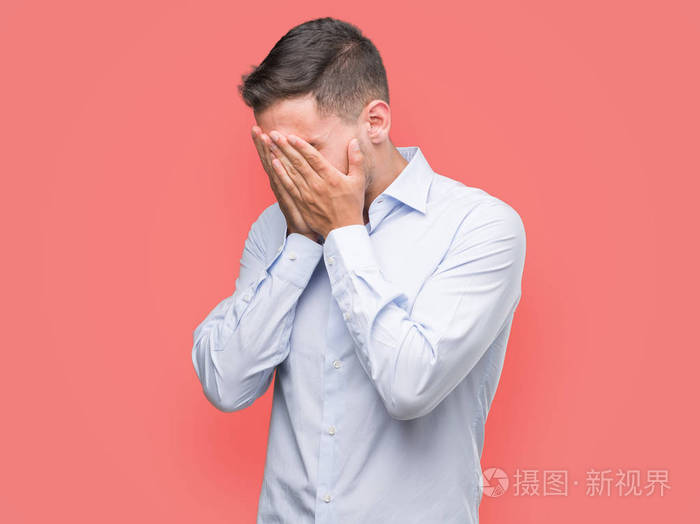 英俊的年轻商人带着悲伤的表情捂着脸用手哭着.抑郁症概念