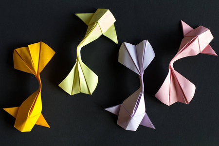 手工纸工艺折纸黄金锦鲤鲤鱼鱼在黑色背景上.顶视图 模式照片