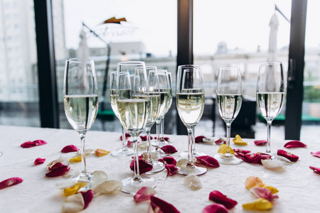 婚礼桌。杯子里有香槟桌上是玫瑰花瓣