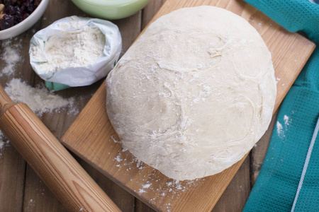 面粉在木板和绿毛巾上的面团照片