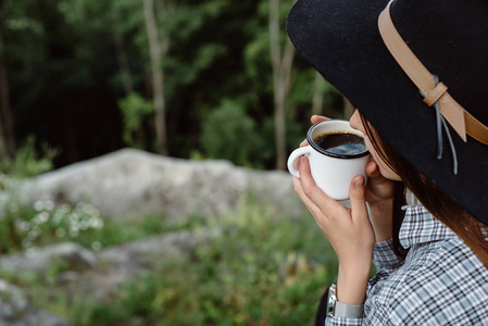 女孩在户外喝咖啡。享受大自然的山顶概念冒险活动假期户外远足运动