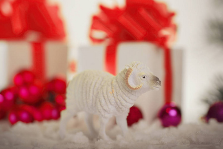 玩具绵羊和礼物的箱子在圣诞节背景