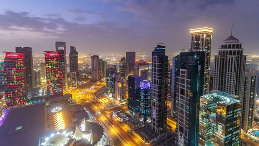 位于西湾地区的地平线, 从多哈天的顶端到夜间过渡 timelapse, 卡塔尔。照亮了现代摩天大楼的鸟瞰从屋顶傍晚后日落。道路交