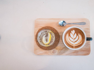 热咖啡画心脏在蓝色杯子在木头纹理与拷贝空间. 顶部视图