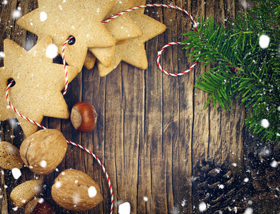 圣诞节曲奇饼 核桃 坚果 松果和枞树枝上木制背景