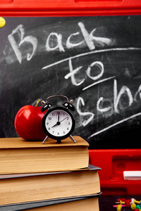 回到学校刻字黑板上的粉笔与书, 铅笔, 红苹果近黑板背景