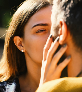 相爱的情侣会接吻的阳光明媚的男人和女人在户外背景下