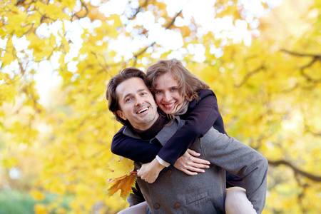 夫妇在片秋色的公园中拥抱