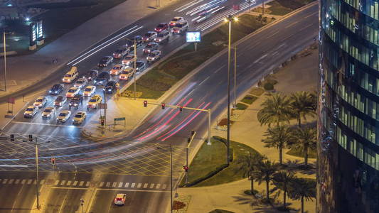 从卡塔尔的多哈 timelapse, 西湾地区的公路上的交通。照亮现代摩天大楼和十字路口鸟瞰从屋顶夜间