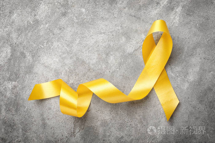 灰色背景上的黄丝带.癌症概念