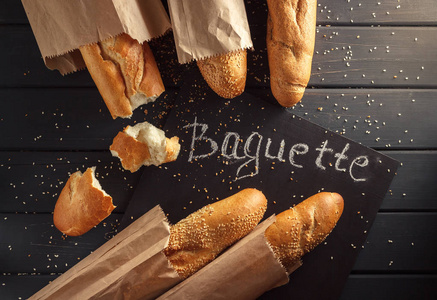 法国长棍面包与芝麻种子黑色木制背景