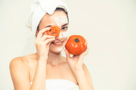 美丽的女人有一个面膜治疗番茄奶油提取物, 显示自然治疗的好处。抗衰老美容面部护肤及奢华生活理念