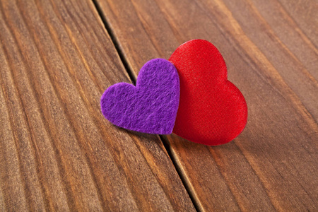 两个彩色的心在一个木制的背景。情人节那天