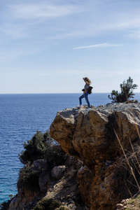 享受海景和站在高大的岩石峭壁上的摄影师