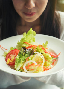 年轻快乐的女人吃沙拉。绿色食品与健康的生活方式