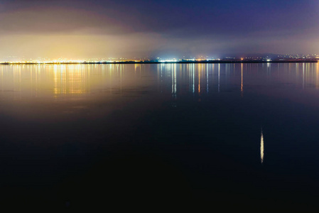 日落时湖上的码头平静的水和放松的灯光的反射