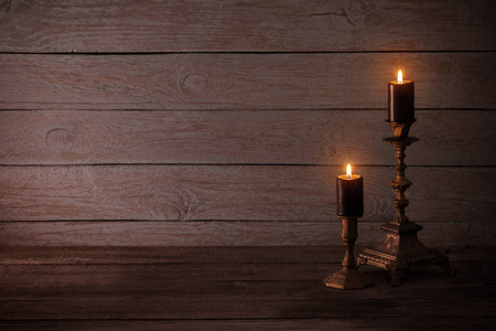 黑色燃烧蜡烛在烛台上老木背景