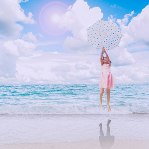 伞上的沙滩，蔚蓝的天空跳跃的小女孩