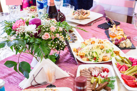 鲜花美食在宴会上招待餐桌.餐馆里有饮料,小吃,美食和鲜花.