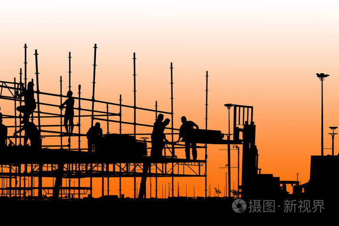 建筑工人的剪影与黄昏天空的脚手架工作