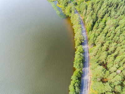 公路鸟瞰图。在湖边一条乡间小路的鸟瞰图。车经过。空中公路。空中鸟瞰飞行。从上面捕获的无人机。柔和照明