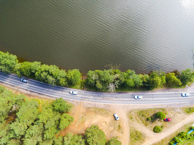 公路与汽车的鸟瞰图。一条乡间小路与移动的汽车的鸟瞰图。车经过。空中公路。空中鸟瞰飞行。从上面捕获的无人机。柔和照明