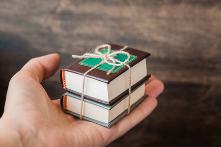 手捧书女性手捧着一摞书本上的木质背景, 知识日概念, 回到学院, 学校