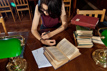 桌子上有绿色灯的图书馆.有棕色家具的老图书馆照片