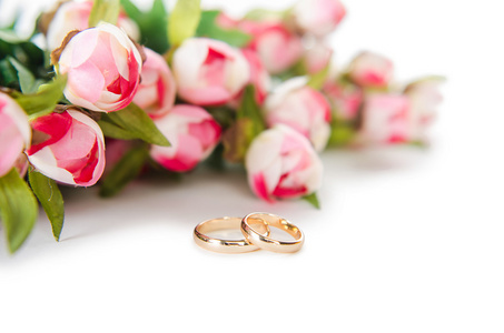 结婚戒指和孤立的白色背景上的花