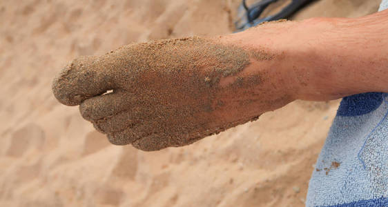 肮脏的脚在沙子里