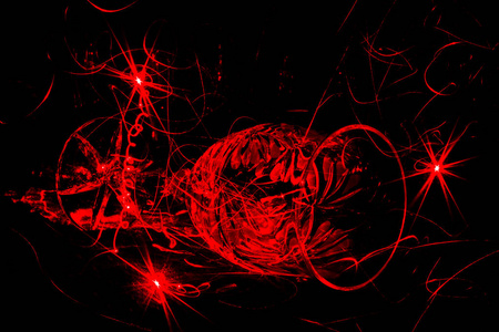 在黑色背景上的水晶酒杯,痕迹的红色激光灯,艺术背景照片