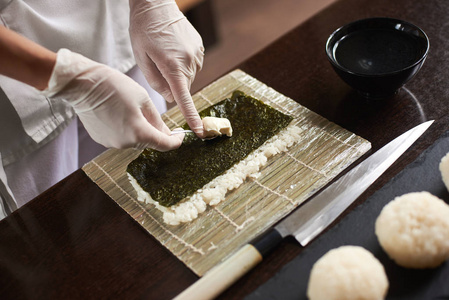 厨师手准备日本料理的特写。日本厨师在餐厅做寿司