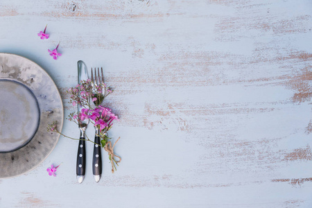 质朴的餐桌设置, 粉红色的花朵在轻木桌上。在普罗旺斯风格的节日装饰。浪漫晚餐具有文本复制空间的顶部视图