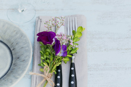 质朴的餐桌设置与紫色的花朵在轻木桌上。在普罗旺斯风格的节日装饰。浪漫晚餐具有文本复制空间的顶部视图
