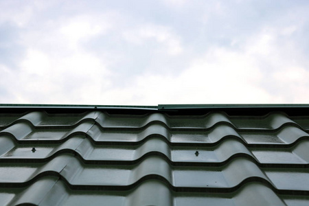 新的绿色屋顶的房子, 铁瓦对蓝天背景特写