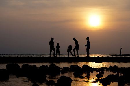 一群人在日落时在海滩上