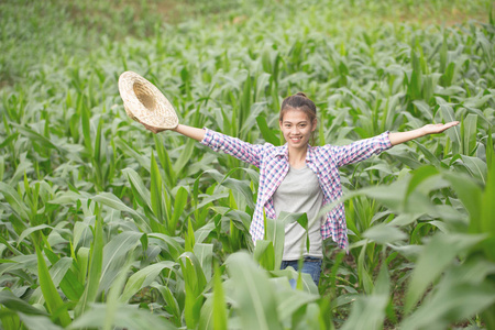 一个年轻漂亮的农夫在他的玉米园里愉快地微笑着