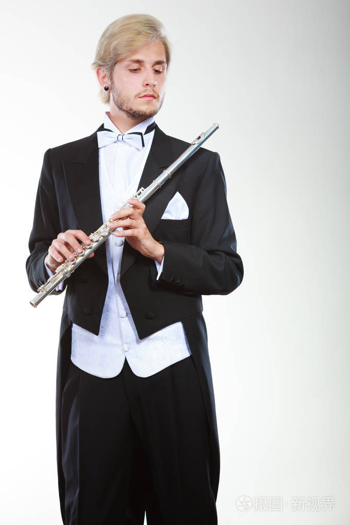 穿着燕尾服的男性长笛演奏家持有长笛